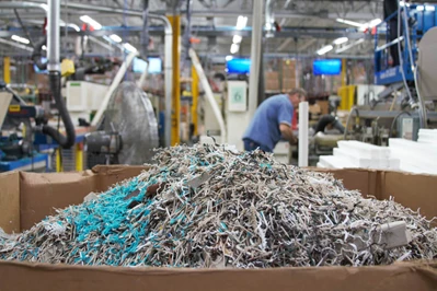 Multi colored plastic scraps from the manufacturing process are stored in a container
