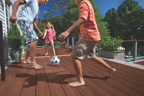 Family Kicking A Ball On A Deck