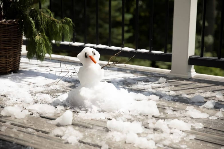 Snowman melting on a composite deck melting in the sun