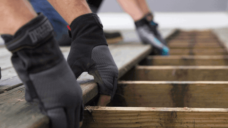 2 people removing a deck board