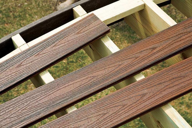 3 Composite deck boards laying on an unfinished deck