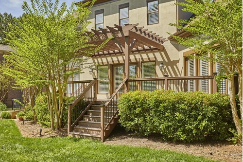 A deck obscured by tress and bushes