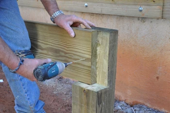 Screw the first piece of the beam to the notched post.