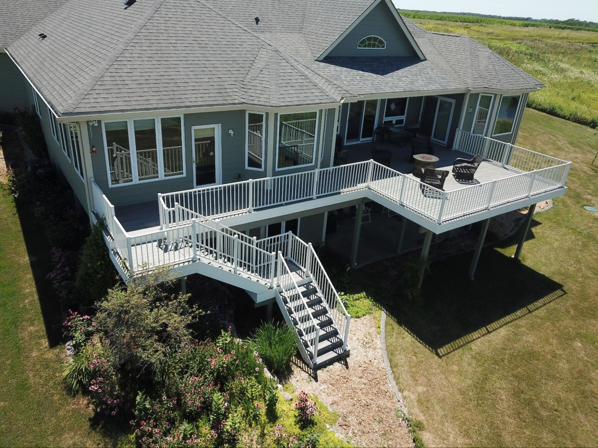 Dark gray house with a light gray patio and white railing