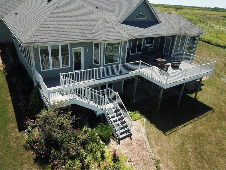 Dark gray house with a light gray patio and white railing