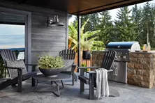 Small outdoor kitchen with a grill and seating for three