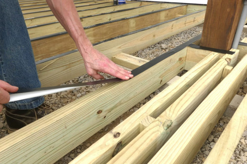Applying Sealing Tape To A Ground Level Deck