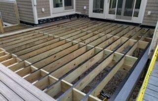 Shows the beams and joists and ledger boards that make up the substructure of a deck.