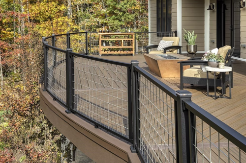 Curved Trex Signature railing with a black aluminum frame and a grey mesh infill on a brown composite deck