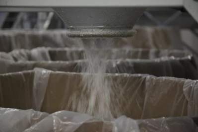 Shredded plastic material falling out of the shredding machine into a box.