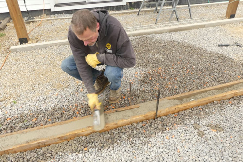 Workman Installing Ground Level Deck Base