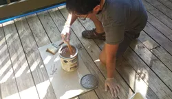 Mixing your wood stain with a stir stick.