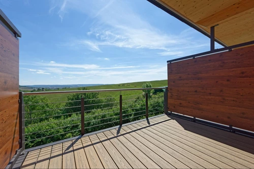 Patio with a privacy fence overlooking a grassy field