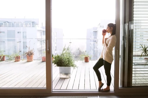 Person Enjoying Coffee On Minimalist Styled Patio Highlighting Simplicity And Coziness