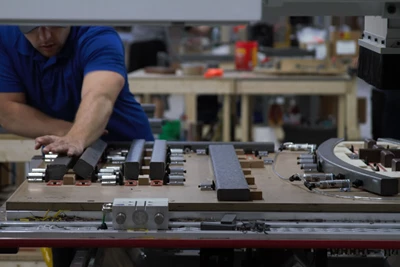 A machinest prepping a machine to produce beautiful outdoor furniture