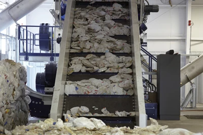 Flattened plastic products traveling on a conveyor belt