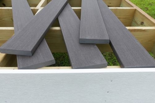 An unfinished capped composite deck sitting atop a deck's frame