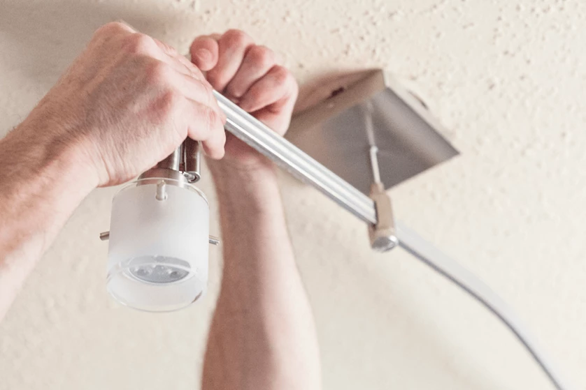 Person installing track lighting